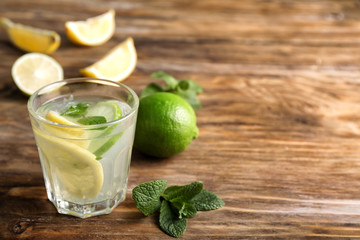 Glass of fresh lemonade on wooden background