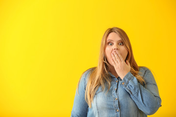 Surprised plus size girl on color background. Concept of body positivity