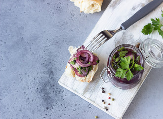 Spicy sliced herring in red wine marinade served in a glass jar.