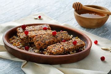 Plate with tasty granola bars on table