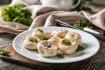 Plate with tasty Chinese dumplings on table