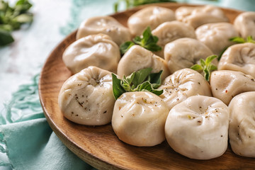 Plate with tasty Chinese dumplings on table, closeup