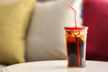 Glass of cold soda on table
