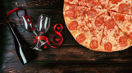 glasses and a bottle of wine on a dark wooden background