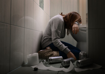 Young vomiting woman near toilet bowl. Concept of alcoholism