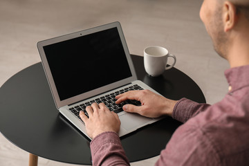 Young man working with laptop at home
