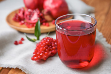 Glass of tasty pomegranate juice on table