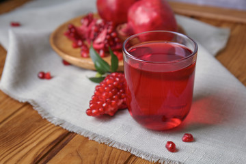 Glass of tasty pomegranate juice on table