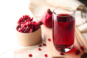 Glass of tasty pomegranate juice on table