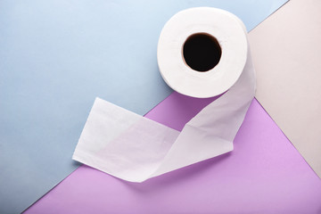 Roll of toilet paper on color background