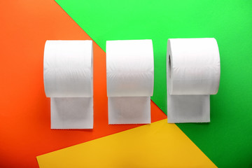 Rolls of toilet paper on color background