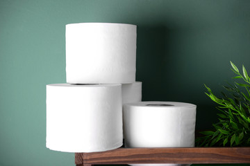 Roll of toilet paper in box on color background