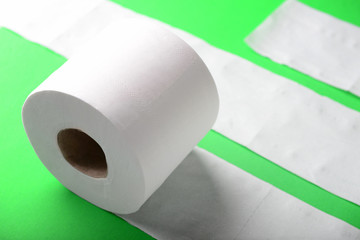 Roll of toilet paper on color background