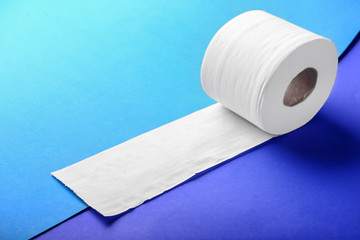 Roll of toilet paper on color background