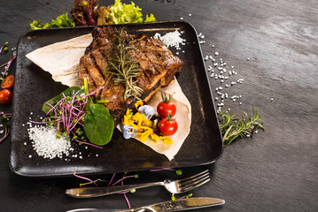Grilled marble steak dish on black background