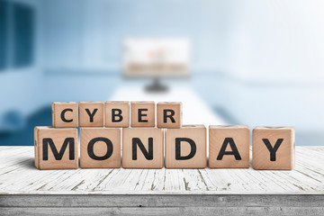 Cyber monday sign on a wooden desk with a monitor