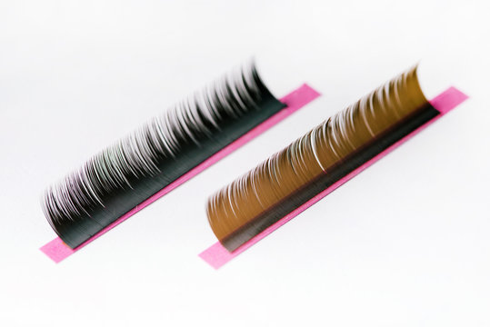 Eyelashes of different colors on a color palette close-up. Macro on white background. Eyelash extension