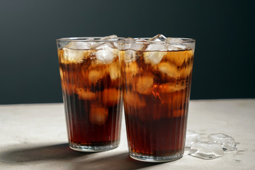 Glasses of tasty soda with ice on table