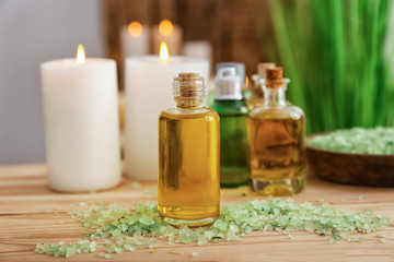 Bottle with essential oil and sea salt on wooden table