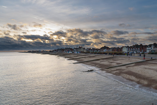 Felixstowe seafront with golden sun behind clouds sky at sunset