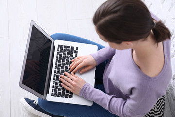 Naklejka premium Young woman working with laptop at home