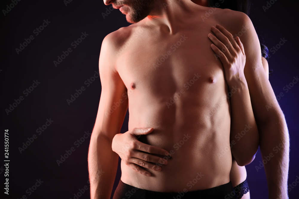 Wall mural Passionate young couple on dark background