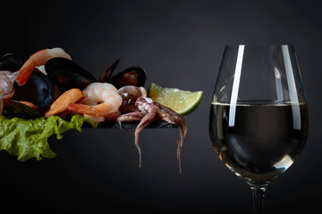 Glass of white wine and mixed delicious seafood.