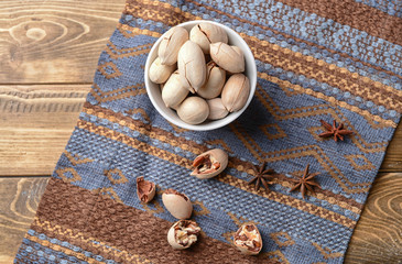 Bowl with pecan nuts on wooden table