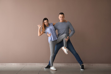 Obraz premium Couple of young dancers near color wall