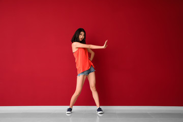 Female Asian dancer near color wall