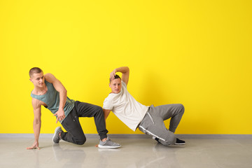 Obraz premium Young men dancing near color wall