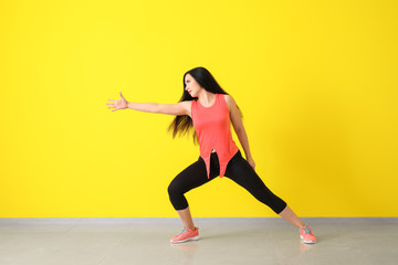 Fototapeta premium Young woman dancing near color wall