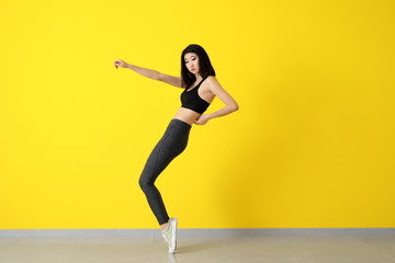 Female Asian dancer near color wall