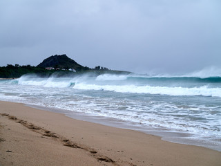 Strong waves hitting beach on stormy day