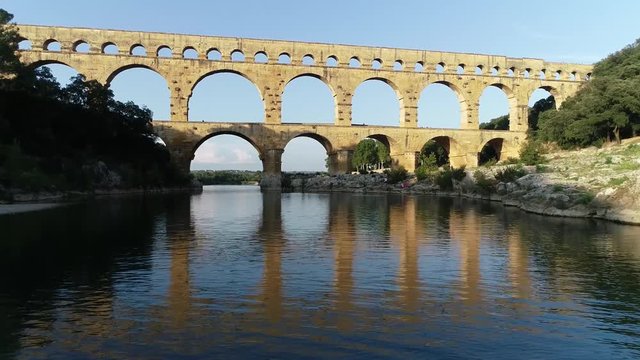 Low altitude aerial footage of Pont du Gard is an ancient Roman aqueduct that crosses the Gardon River near the town of Vers-Pont-du-Gard in southern France and popular tourist destination 4k quality