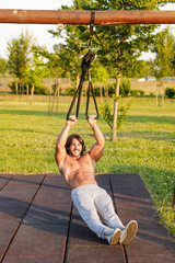 Young man with six-pack exercising in the park