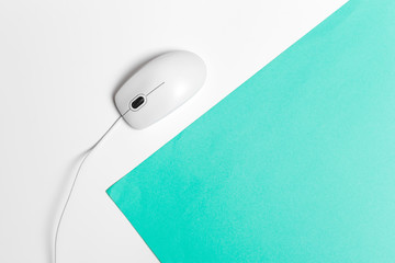 Computer mouse on a turquoise paper background
