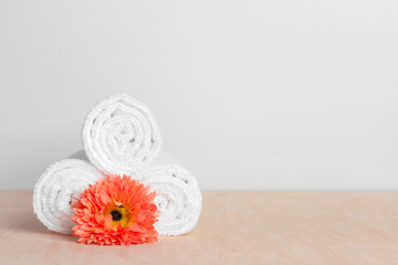clean soft towels with flower on wooden table