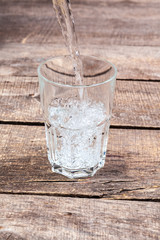Glasses of water on a wooden table.