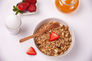 A plate with muesli, strawberries, juice and milk on a white background. Top view.
