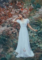 mysterious lady alone in colorful fairy forest, dancing with her eyes closed, raising her hand to...