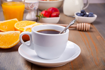 Cup of coffee and fruits and berries on the wooden table