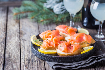 Plate of fresh salmon fillet with bread on wooden background