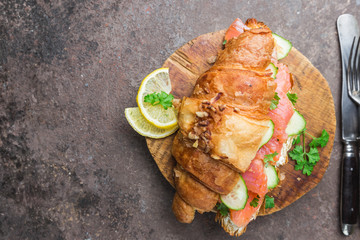 smoked salmon sandwich with cream cheese fresh and cucumbers on cutting board, top view