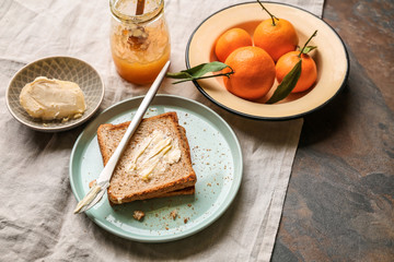 Bread with butter and tasty tangerine jam on table