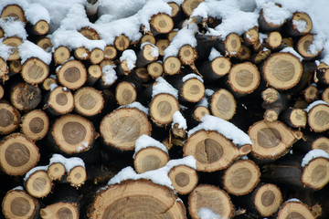 Village life, a woodpile covered with snow in the backyard. Woodpile in winter lies in the snow.