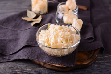 Bowl with tasty fermented cabbage on wooden table