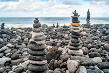 Many stone stacks on the beach near ocean