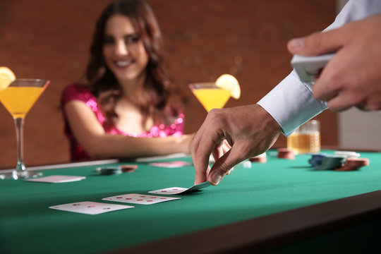 Male banker putting cards on table in casino