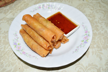 Fried spring rolls with sweet chili sauce in a white plate, Chinese street food
